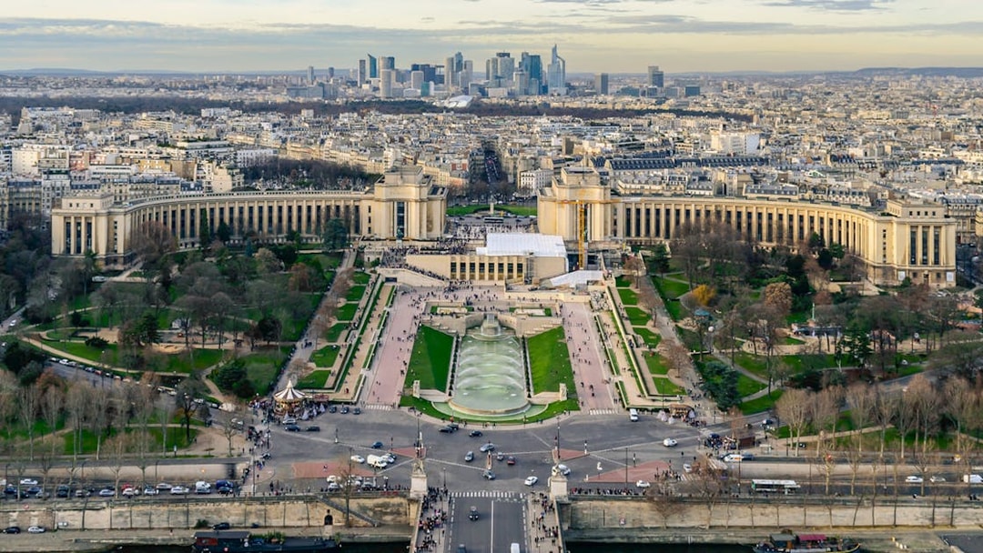 Panoramic view of Paris from Eiffel Tower Summit, featuring Trocadéro Gardens and cityscape.
