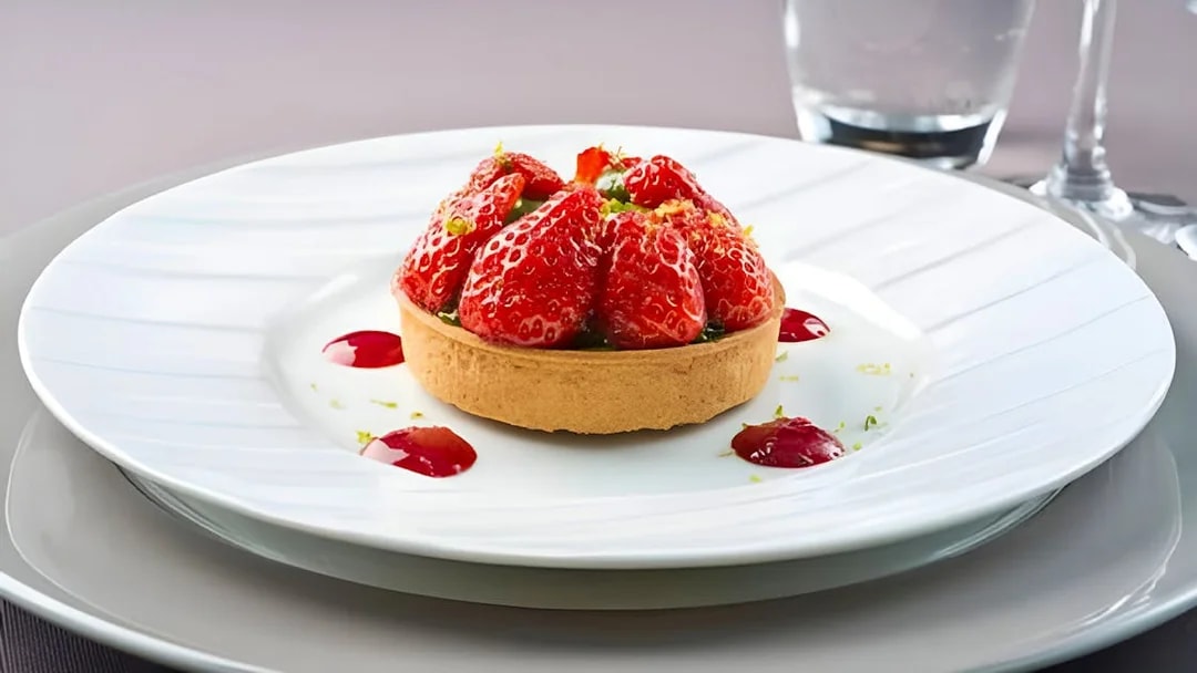 Strawberry tart served on a white plate during Bateaux Parisiens lunch cruise in Paris.