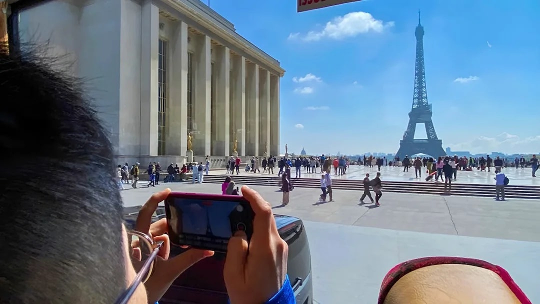 Person photographing Eiffel Tower from Trocadéro, Paris during day trip.