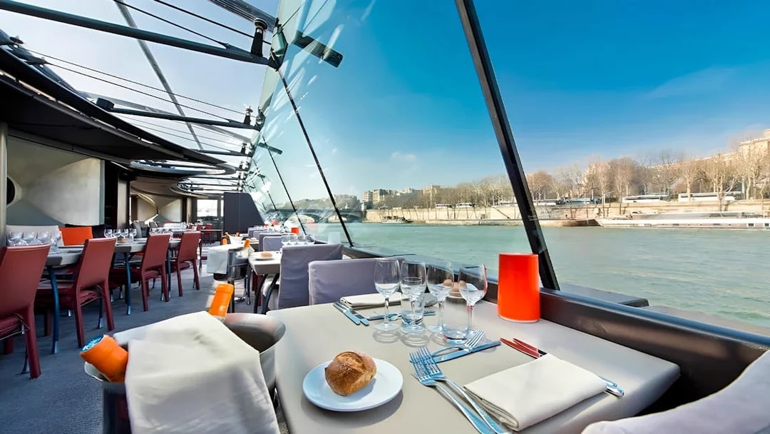 Bateaux Parisiens lunch cruise table setting with Seine River view in Paris.