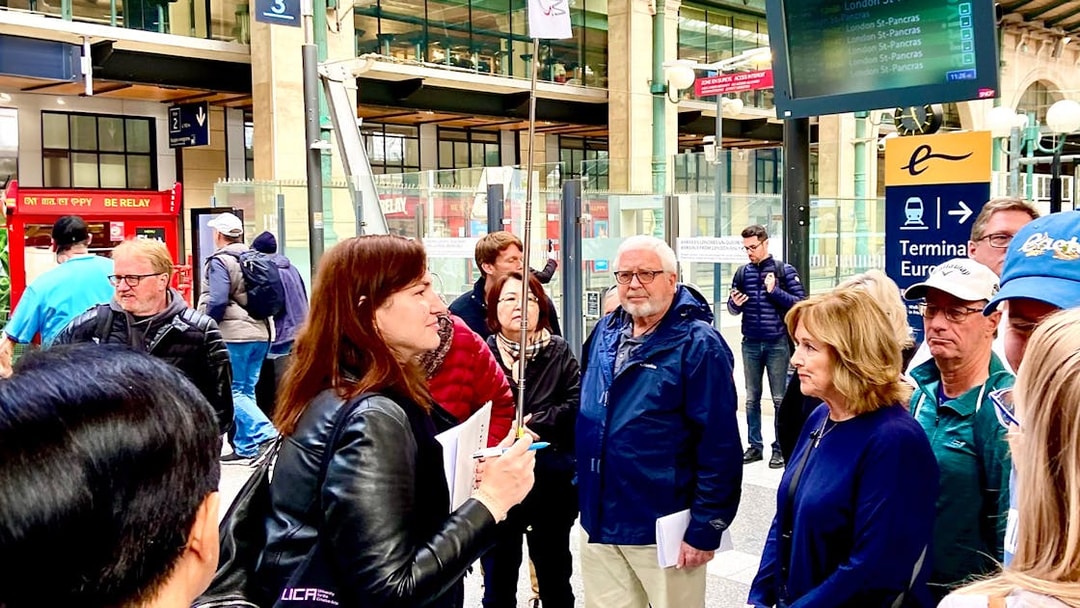 Group of tourists at a Paris train station, preparing for a day trip with lunch on the Eiffel Tower.