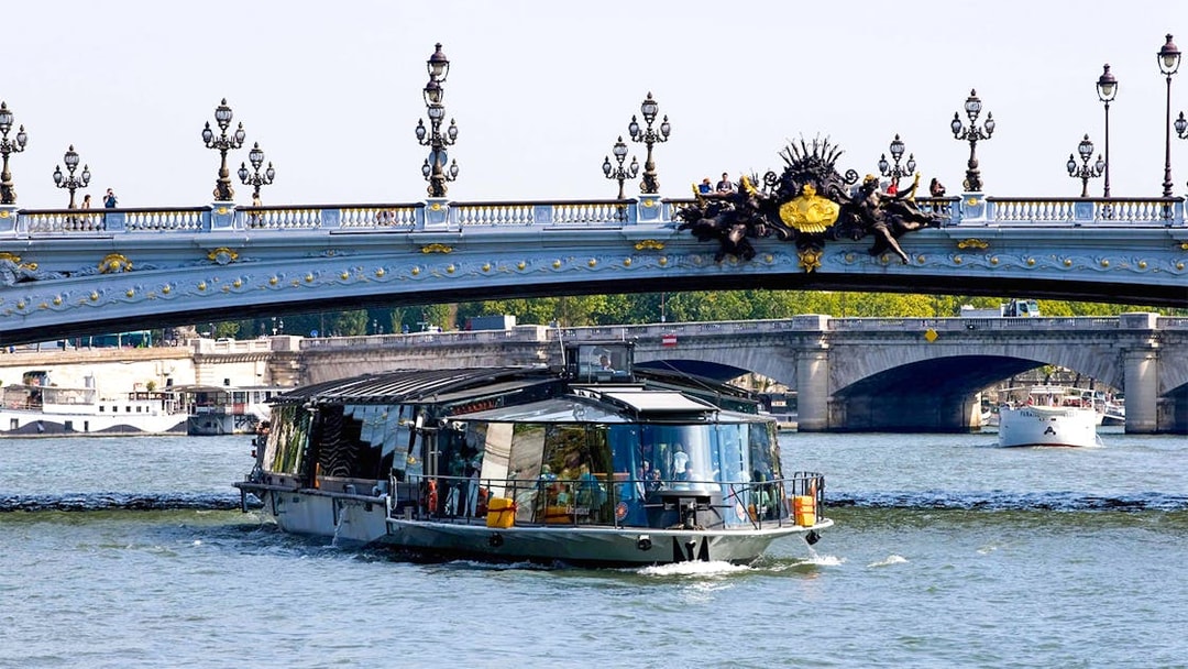 Bateaux Parisiens cruise on the Seine River under Pont Alexandre III in Paris.