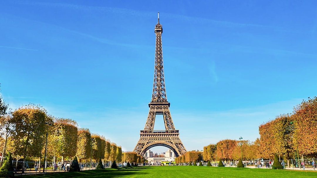 Eiffel Tower view from second floor with Paris cityscape in background.