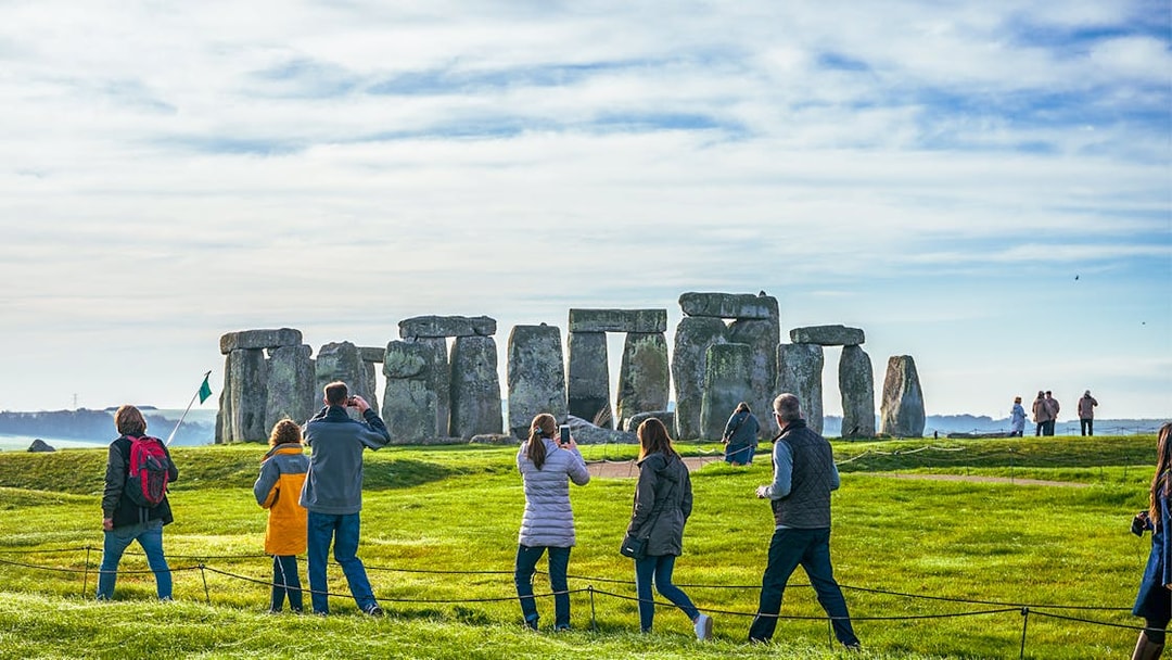 Tourists at Stonehenge, viewing ancient stone structures on a day trip from London.
