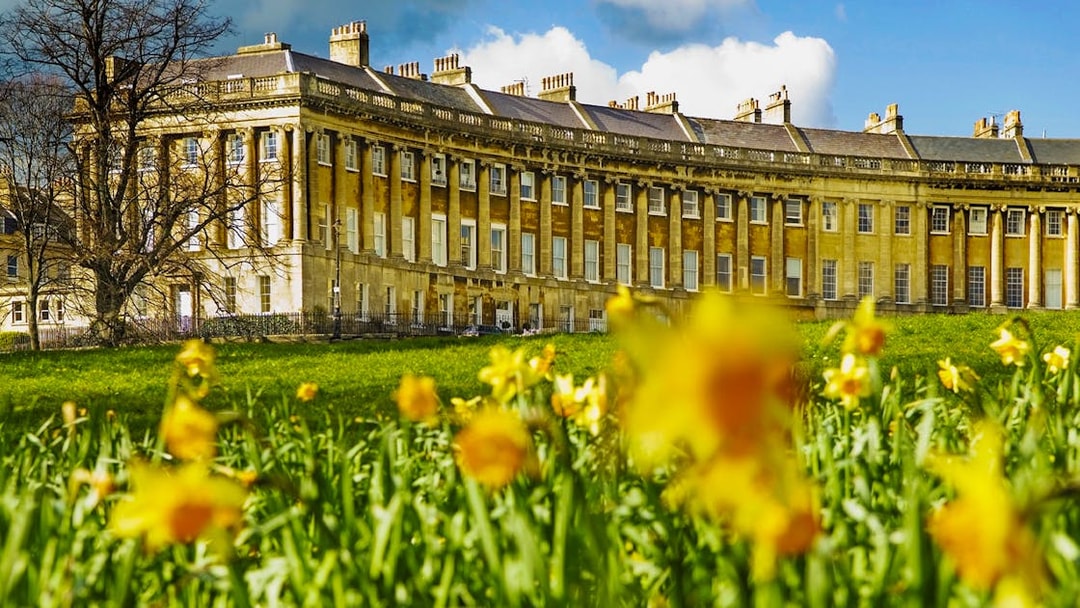 Royal Crescent in Bath, UK with blooming daffodils in the foreground.