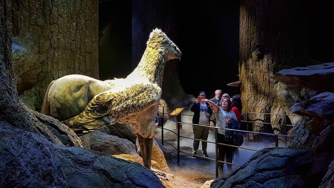 Visitors at Harry Potter Studios with Buckbeak model, London film location tour.