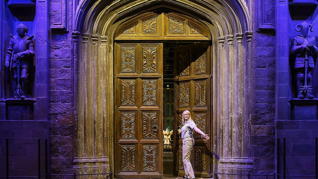 Entrance to the Great Hall with ornate wooden doors and stone statues.