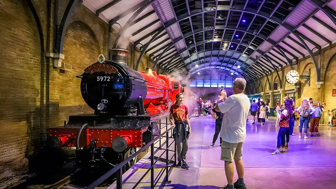 Hogwarts Express at Warner Bros. Studio Tour London with visitors taking photos.