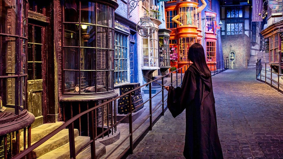 Visitor in wizard robe exploring Diagon Alley set at Warner Bros. The Making of Harry Potter Studio Tour.