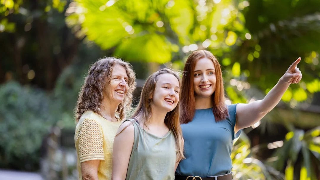 Tourists enjoying a day at Lone Pine Koala Sanctuary, surrounded by lush greenery.