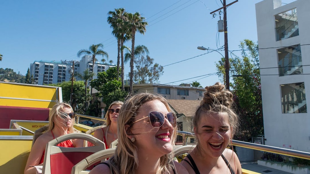 Tourists enjoying a sunny day on a Los Angeles hop-on hop-off bus tour.