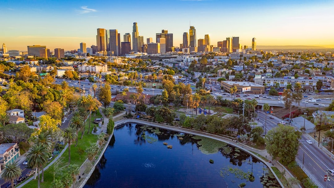 Downtown Los Angeles skyline with high-rise buildings and urban landscape at sunset.