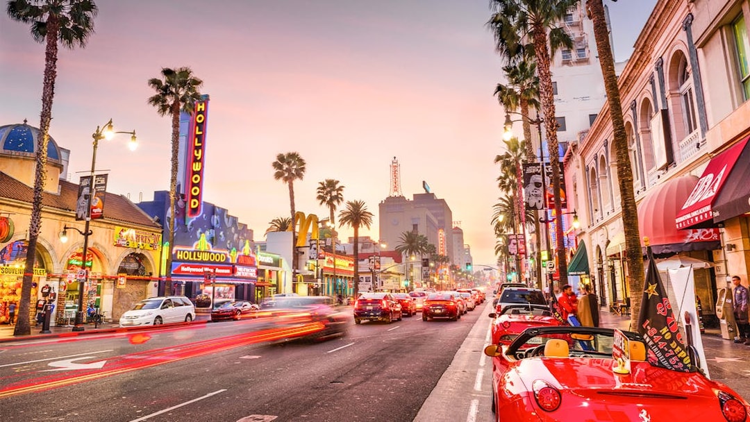 Hollywood Boulevard at sunset with neon signs and palm trees, part of TMZ Hollywood Tour.