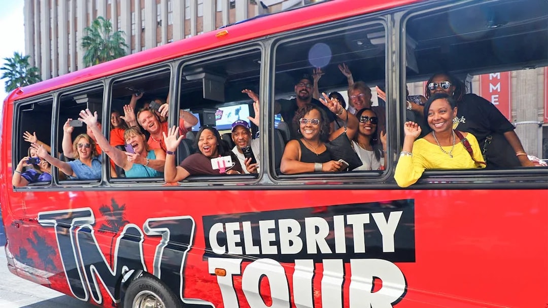 Tourists waving from TMZ Celebrity Tour bus in Hollywood.