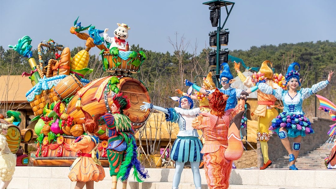 Performers in colorful costumes during a parade at Lotte World Adventure Busan.