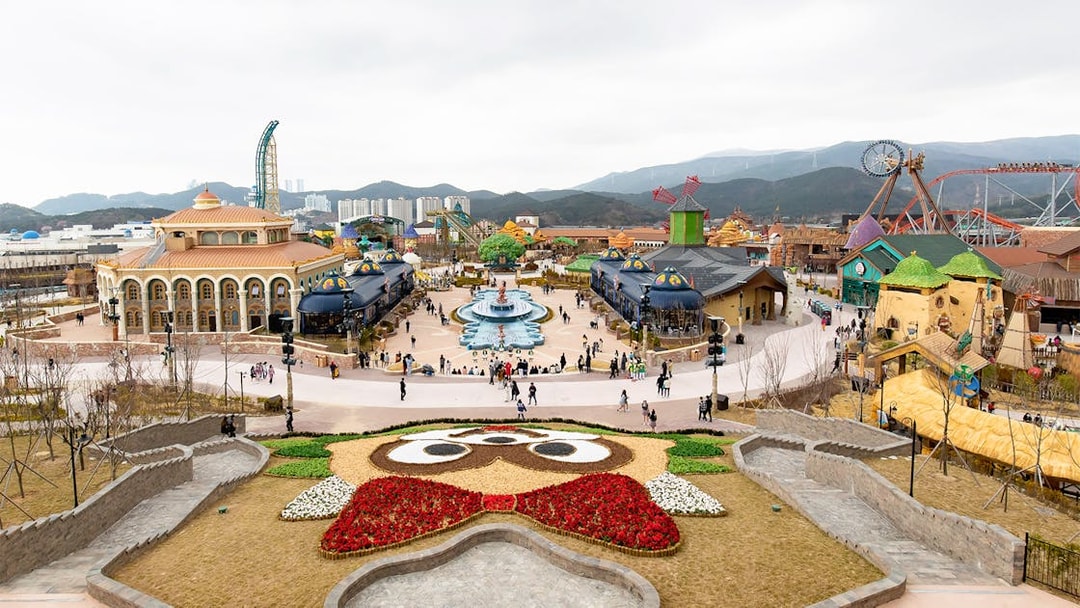 Lotte World Adventure Busan theme park with colorful buildings and a central fountain.
