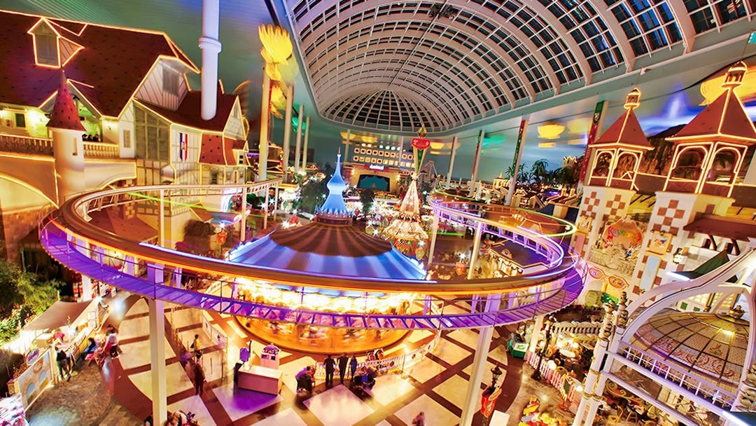 Indoor amusement park ride at Lotte World, Seoul, featuring colorful lights and a domed ceiling.