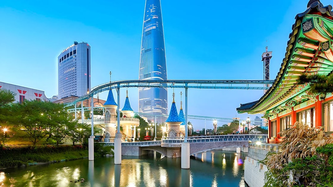 Lotte World park with monorail, traditional Korean architecture, and skyscraper in Seoul.