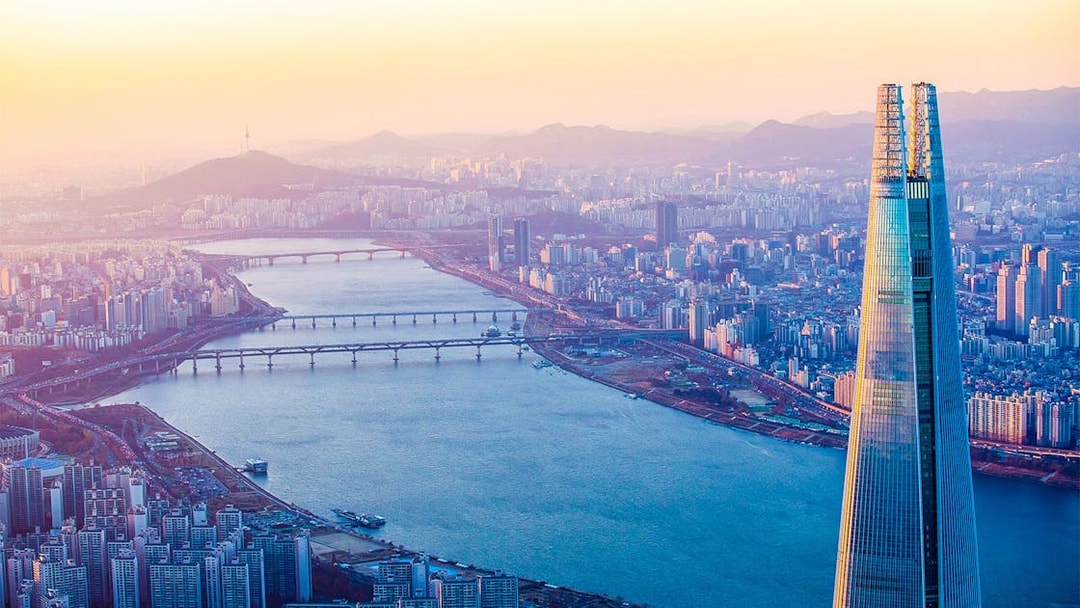 Lotte World Tower overlooking Han River in Seoul at sunset.