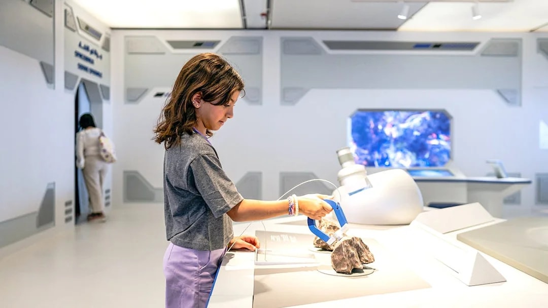 Young visitor exploring exhibit at Louvre Abu Dhabi.