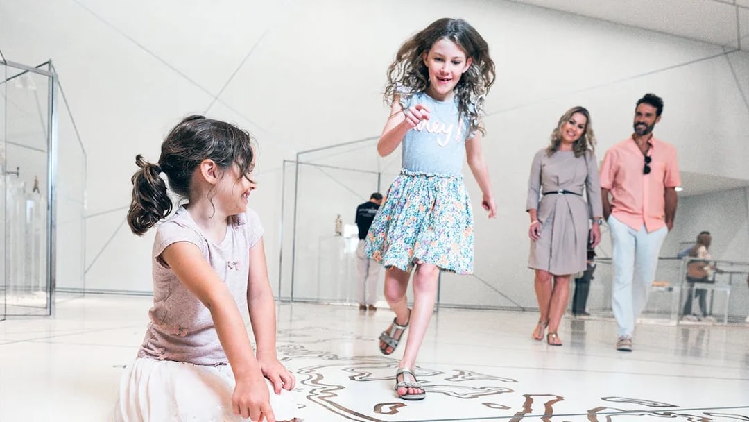 Visitors enjoying interactive exhibits at the Louvre Museum Abu Dhabi.