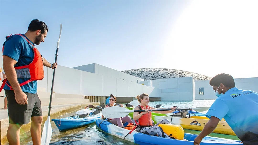 Visitors preparing for a guided kayak tour at Louvre Abu Dhabi.