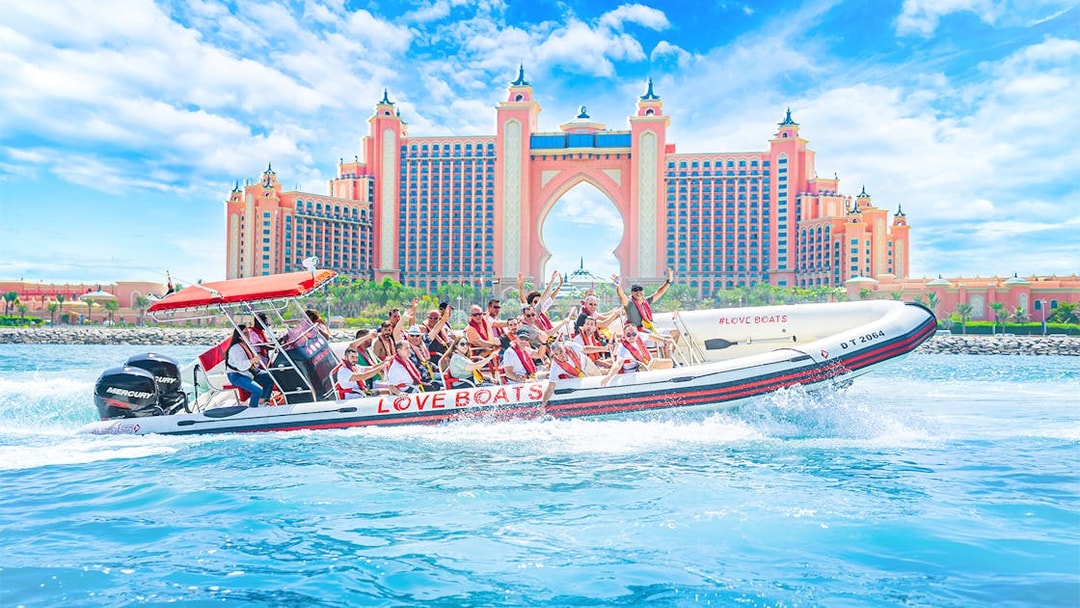 Tourists on a Love Boats speedboat near Atlantis, The Palm in Dubai.