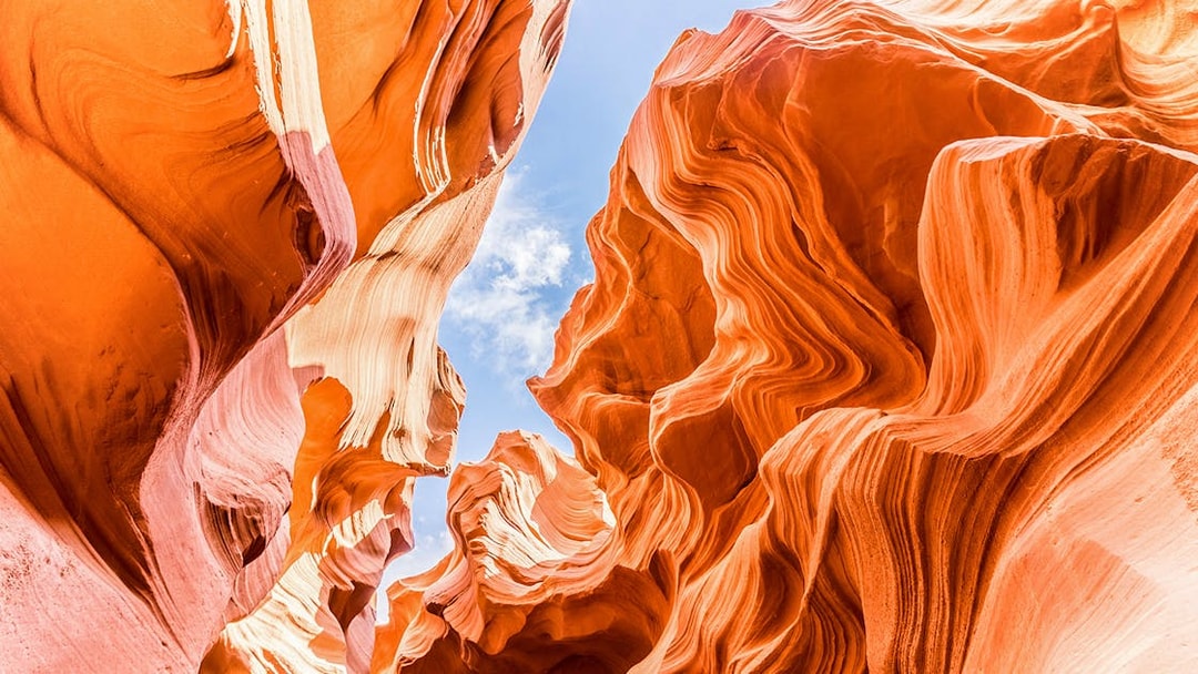 Lower Antelope Canyon's swirling sandstone formations under a clear blue sky.