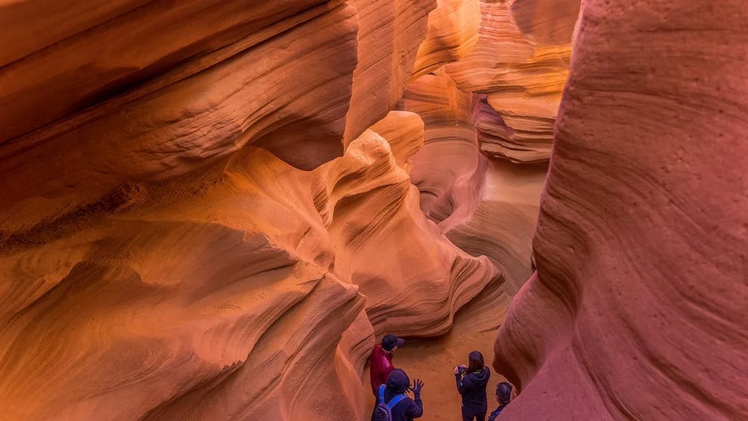Tourists navigating the narrow pathways of Lower Antelope Canyon on a guided tour with Ken's Tours.