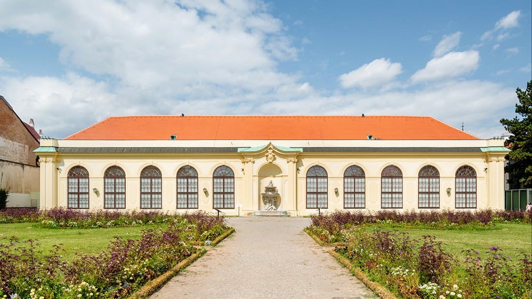Upper Belvedere Palace garden view, Vienna, with historic architecture and vibrant flower beds.
