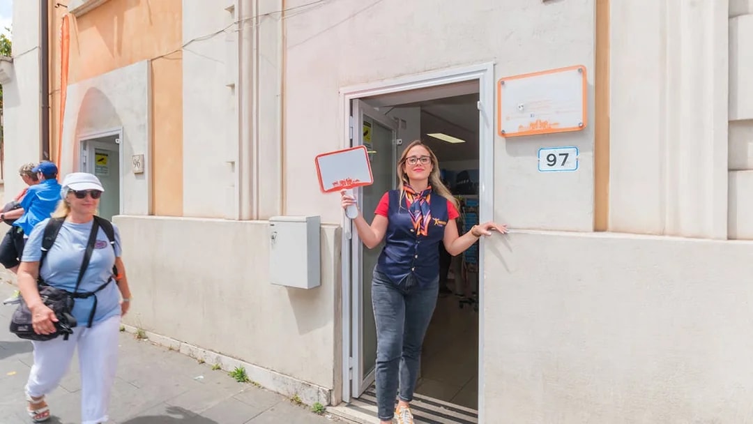 Luggage storage entrance in Rome with staff member welcoming visitors.