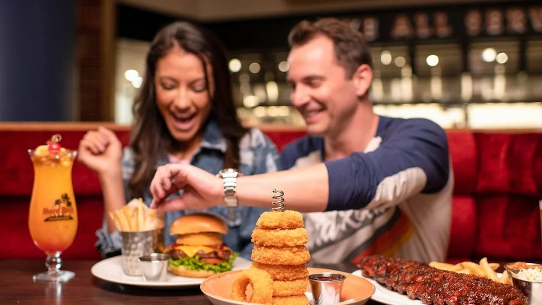 Couple dining with burgers and drinks at Hard Rock Cafe, Milan.