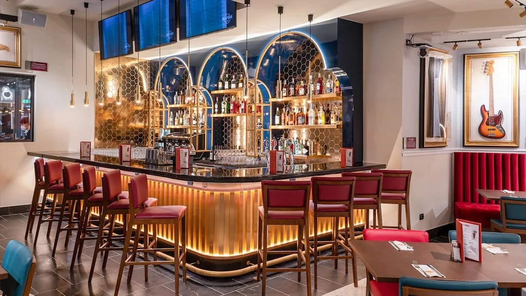 Hard Rock Cafe Milan bar area with seating and guitar decor.