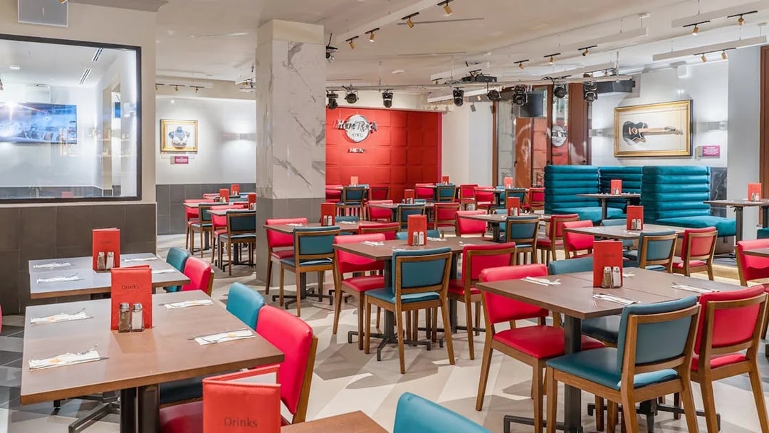 Dining area at Hard Rock Cafe Milan with red and blue seating and iconic decor.
