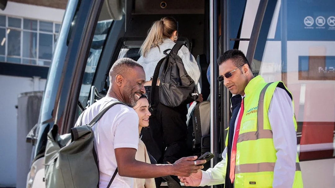 National Express staff checking passenger tickets as they board the bus.