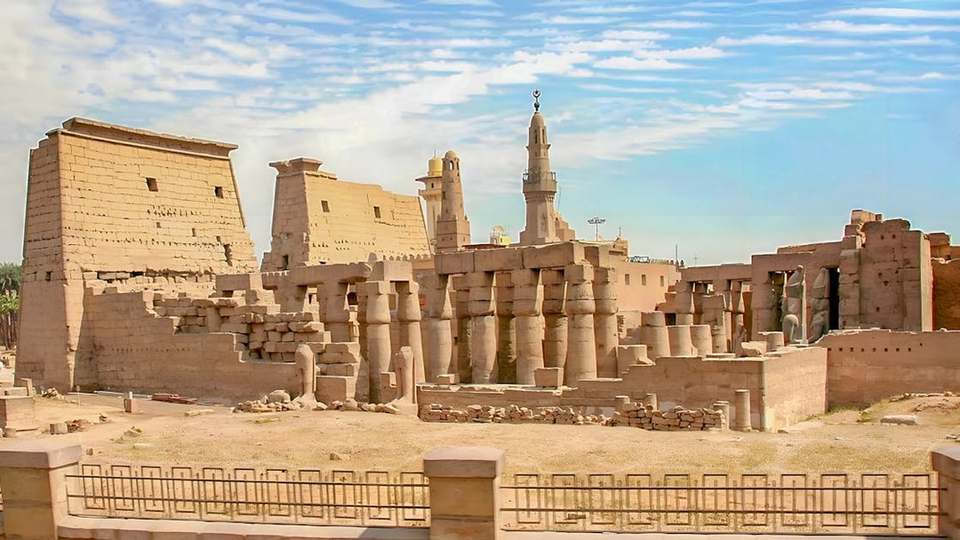 Luxor Temple ruins with ancient columns and pylons under a blue sky in Egypt.