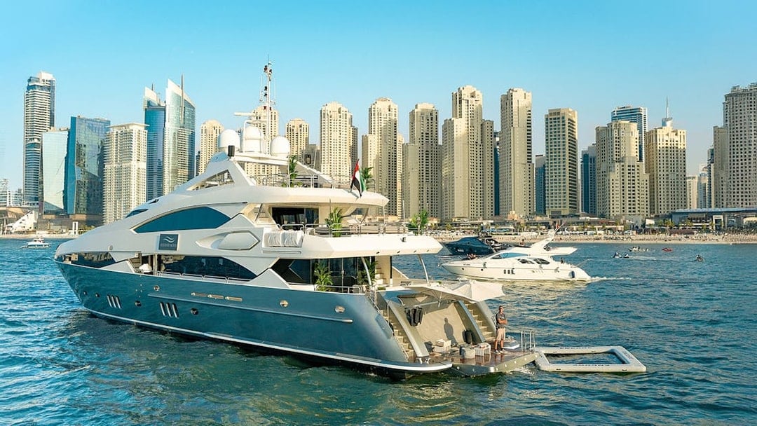 Superyacht on Dubai Marina with city skyline, offering gourmet dining and live music experience.