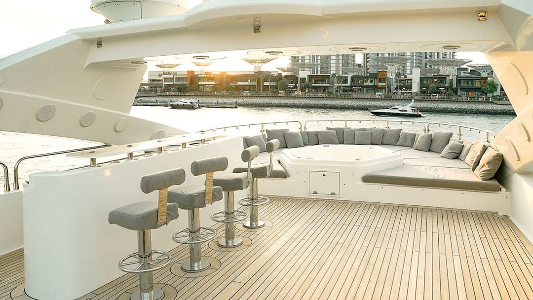 Sunseeker superyacht deck with bar stools, lounge seating, and waterfront view.