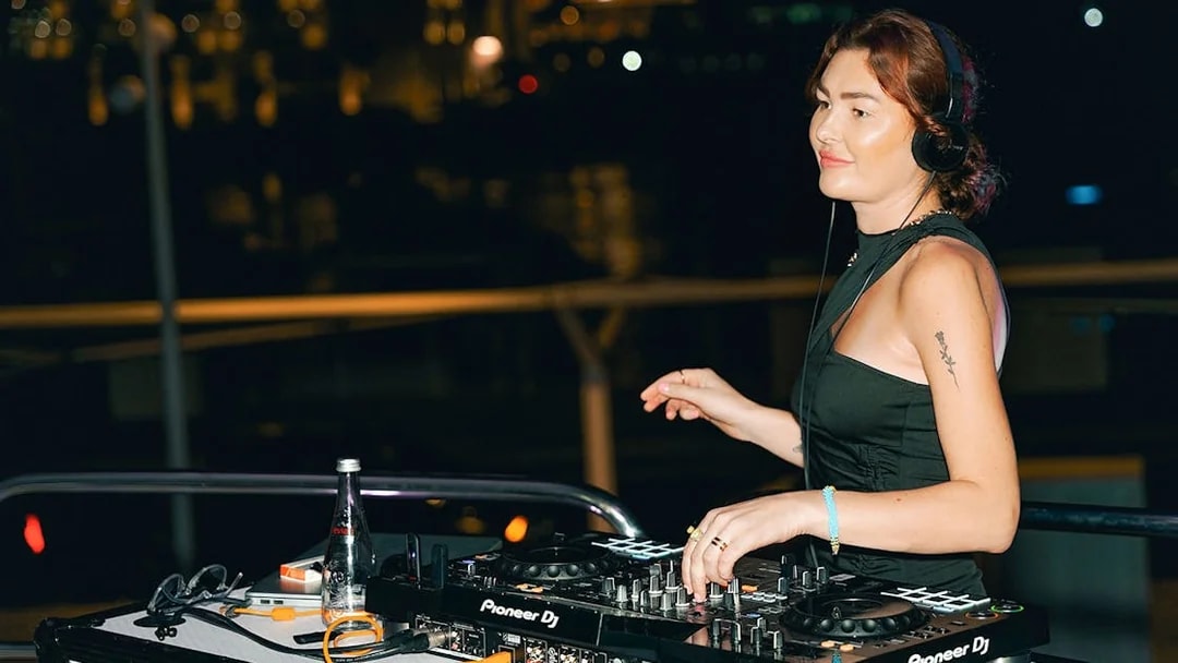 DJ performing on Sunseeker superyacht with music equipment at night.