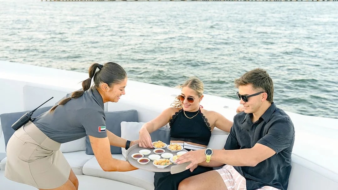 Server offering gourmet appetizers to guests on a Sunseeker superyacht.