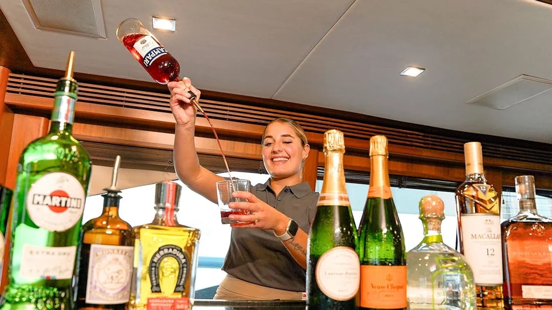 Bartender preparing a cocktail on a Sunseeker superyacht with premium spirits and champagne.