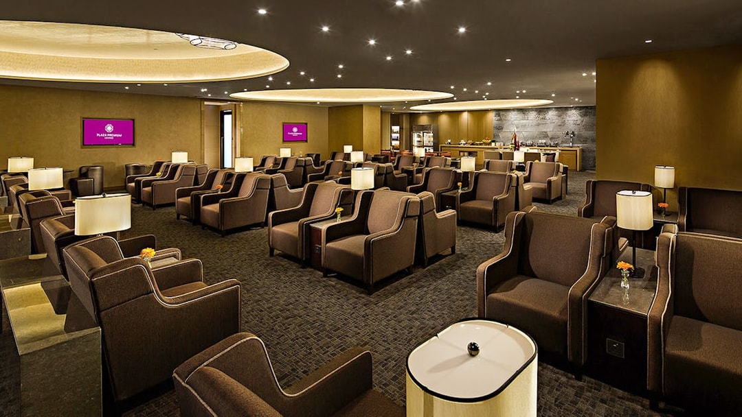 Plaza Premium Lounge seating area with armchairs and ambient lighting.
