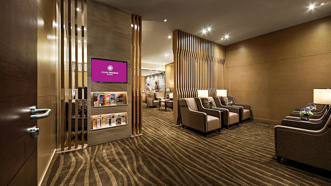 Plaza Premium Lounge seating area with armchairs and magazines.