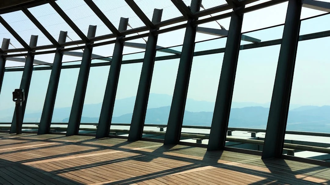 Observation deck view from Macau Tower with mountains in the background.