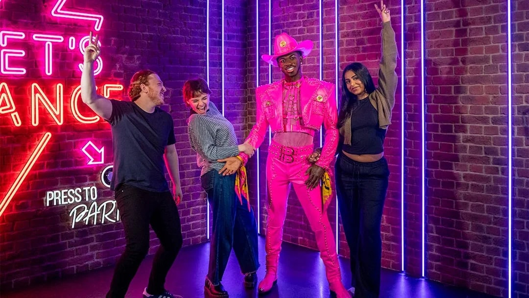 Visitors posing with Lil Nas X figure at Madame Tussauds London.
