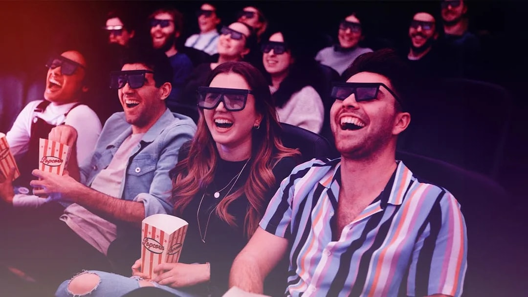 Group enjoying a 3D movie experience with popcorn in a theater.