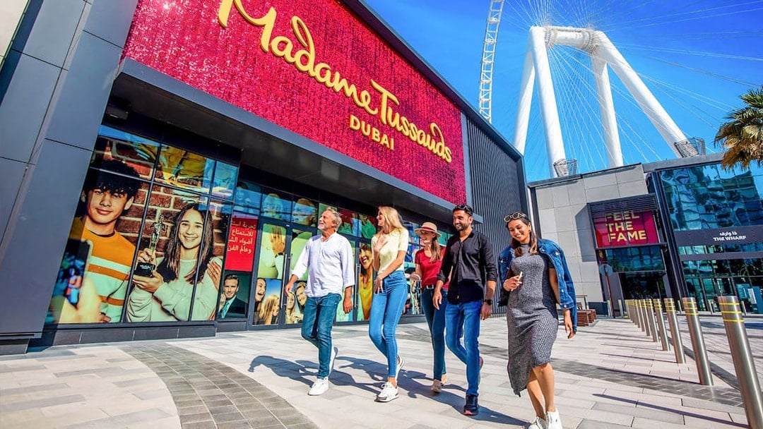 Visitors walking outside Madame Tussauds Dubai with Ain Dubai in the background.