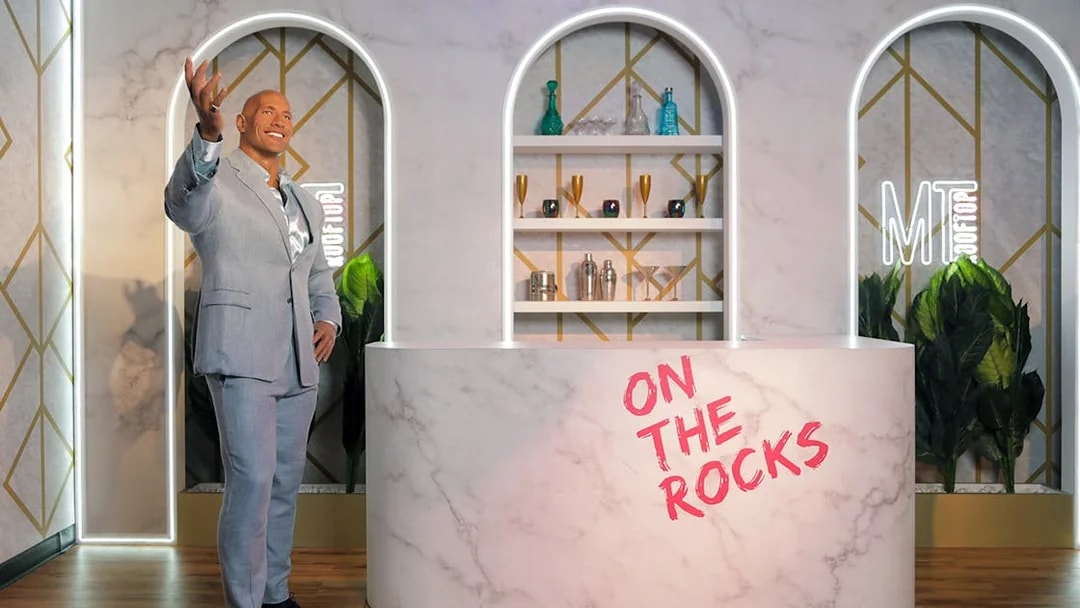 Dwayne Johnson wax statue at Madame Tussauds Dubai in a bar setting.