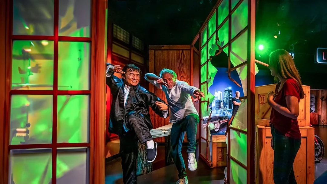 Jackie Chan wax figure with visitors posing in action at Madame Tussauds Dubai.