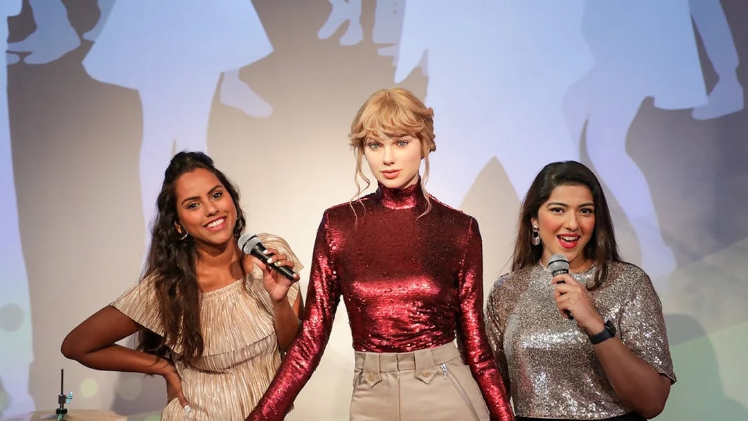 Fans posing with Taylor Swift wax figure at Madame Tussauds Dubai.